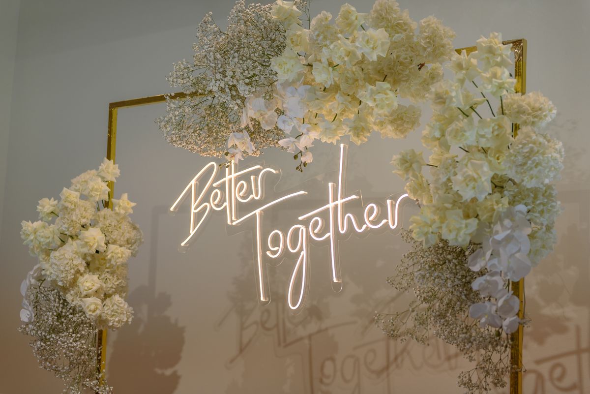 Wedding photo booth Fort Worth flower wall backdrop with 'Better Together' neon sign